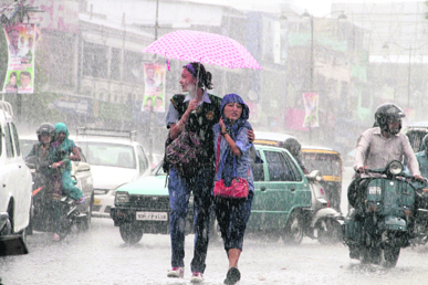 Girls enjoy rain that lashed Dehradun on Saturday.