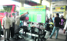 Punjab Roadways employees show the timetable hoarding of a private bus operator at Shaheed-E-Azam Inter-State Bus Terminal in Jalandhar on Saturday.
