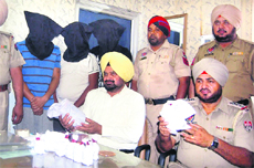 Police officials show the recovered contraband (opium) from the three accused (with covered faces) in Kapurthala on Saturday