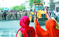 Residents of the Prajapat Colony stand in protest against the demolition drive in Bathinda on Sunday. A large police force had also been deployed in the colony to handle the protesting crowd