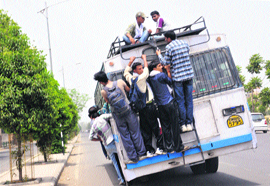 Candidates for railway exam take a risky ride at Phase VII in Mohali on Sunday.