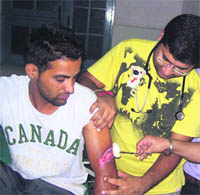 A doctor examines Prabhjot Singh, the victim, at a hospital. 