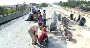 Workers giving final touches to the flyover on Gill Road along the Sidhwan expressway in Ludhiana. 