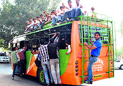 Passengers travel on the rooftop of an overcrowded bus in Patiala