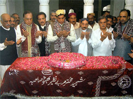 Pak PM Raja Pervez Ashraf (C), offers prayers along with party leaders over the grave of slain former Pakistani premier Benazir Bhutto in Garhi Khuda Bakhsh. 