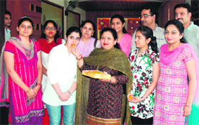 BBK DAV College for Women principal Neelam Kamra offers sweets to meritorious students of BSc (biotechnology-III) in Amritsar on Monday