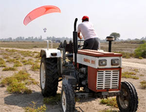 A man paraglides after using a tow winch machine attached to a tractor in Charewan village near Muktsar. 