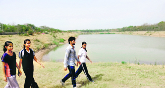 Residents take a stroll near a lake in Dhanas near Panjab University in Chandigarh.
