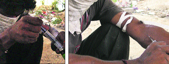 A youth in Ludhiana fills an injection with psychotropic drugs and injects himself.