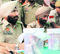 SSP Gurpreet Singh Gill (left) shows fake currency recovered from four persons in Patiala on Monday. 