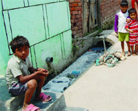 A child sits besides an open drain in Amritsar. Photo: vishal kumar