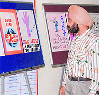 Prof Jasbir Singh, chairman, campus cultural committee, looks at posters in Jammu University