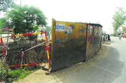 Metal boards placed around ditches dug up by a private contractor for constructing a foot overbridge in Doraha. Photo by writer