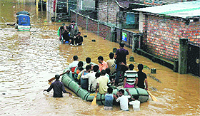  People use a rubber boat in a waterlogged street of Anil Nagar after a heavy downpour in Guwahati on Tuesday.