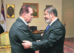 Caretaker Prime Minister Kamal el-Ganzouri (L) with newly elected President Mohammed Morsi in Cairo