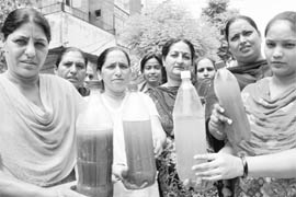 Residents show muddy water at the MIG quarters in Phase X of Mohali on Wednesday.