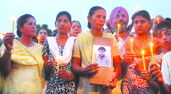 Sarabjit's wife Sukhpreet (with a picture), daughters Swapandeep and Poonam during a candlelight march in Jalandhar on Wednesday.