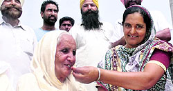 Surjit Singhs wife Harbans Kaur and her daughter-in-law celebrate news of his release with laddoos