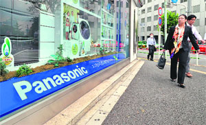 Pedestrians walk past a showroom of Japanese consumer electronics giant Panasonic in Tokyo on Thursday. The firm reported its largest-ever group net loss of 772 billion yen (US $9.65 billion) in fiscal 2011 ended in March.