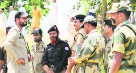 BSF personnel share a lighter moment with a Pakistan ranger at Chamliyal post in Samba district.