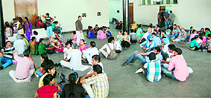 Admission seekers wait for their turn outside an auditorium