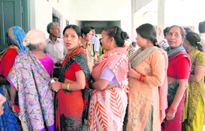 Women wait to cast their vote in the Municipal byelections in Dehradun on Friday.