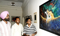 Visitors at a painting exhibition in Amritsar on Saturday. Photo: Vishal Kumar
