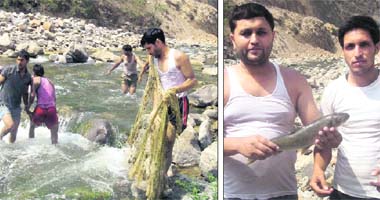 Villagers throw nets in the Aglar rivulet during the Maund festival near Mussoorie on Saturday; and (right) revellers with a prized catch