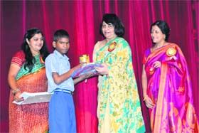 A child of Apna Ghar being given a schoolbag and chocolates during a function of the ONGC Mahila Club in Dehradun on Saturday