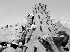 Residents of Timbuktu restore the City of 333 Saints Great Mosque prior to the Maouloud festival marking the birth of Prophet Mohammed in this file photo