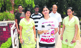 A student stands in protest with her family in front of the residence of Suman Kocchar at Sector 24, Chandigarh, on Sunday.