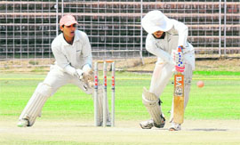 A player hits a defensive stroke during the match between Chandigarh and Mohali at Sector 16 in Chandigarh on Sunday.