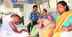 Patients and attendants sit in an ambulance. 