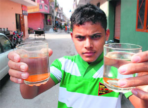 A boy shows contaminated water at Vikas Nagar in Chandigarh on Sunday.