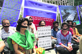 Members of the Ganga Aawahan, an NGO, stage a dharna in Dehradun on Sunday.