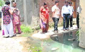 A health team takes a look at sewage accumulated in a street at Basti Peerdad in Jalandhar on Sunday