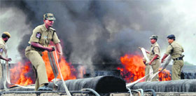 Policemen try to douse flames on the roof of the Jubilee Hall in Hyderabad where Pranab Mukherjee held a meeting with AP Congress MPs and MLAs on Sunday.