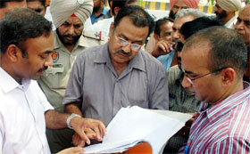Officials try to figure out the confusion that arose during the demolition drive in Moga on Monday.