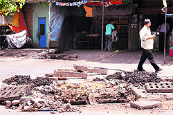 After a sewer is cleaned, sewage is lying near the road gully at Bapu Dham Colony in 