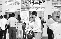 People line up at a counter in the Civil Hospital, Phase VI