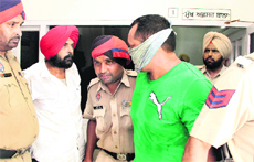 Kuldeep Singh Keepa (face covered) argues with Dr Gurvinder Singh Samra in police station after the former tried to shoot the latter in the Judicial Court complex in Jalandhar on Monday. 