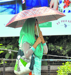 A girl covers her face as temperatures soar in Jammu on Monday.