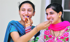 Jaspreet Kaur (left) and Jasmine Puri celebrate after attaining top positions in Panjab University examinations in Ludhiana on Monday.