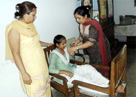 Teachers attend to a student after she fainted in classroom at a government school in Amritsar on Tuesday