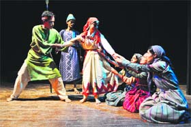 Artistes enact a scene from a play, Dugath Dhenu, at the Gaiety Theatre in Shimla