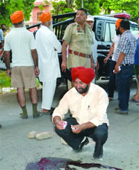 Police officials inspect the murder site in the Kabir Park area in Amritsar on Wednesday.