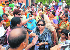 Residents argue with Mayor Raj Bala Malik (cropped hair) over insanitary conditions prevailing at Vikas Nagar in Chandigarh on Wednesday.