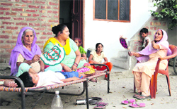 Women use hand fans during an unscheduled power cut to beat the heat while sitting outside their houses at Bhargo Camp locality in Jalandhar. Photo: Sarabjit Singh