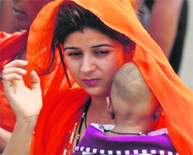 A woman protects her child from the scorching heat in Jammu on Wednesday