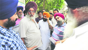 MC officials argue with Harpreet Singh Bedi (in orange turban) in Sunet village in Ludhiana. 